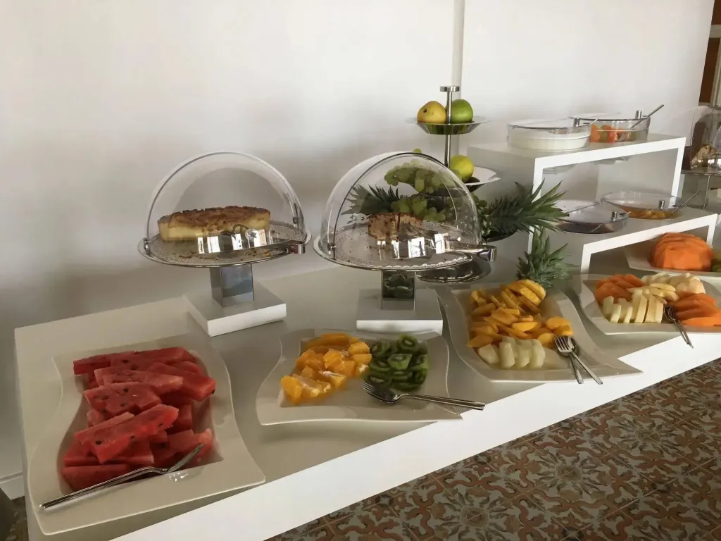 Présentation de fruits frais et de pâtisseries sur un buffet.