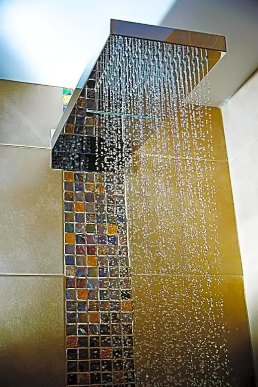 Une douche à pluie moderne avec des carreaux décoratifs.