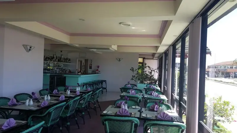 Une salle lumineuse avec des tables dressées pour le service.