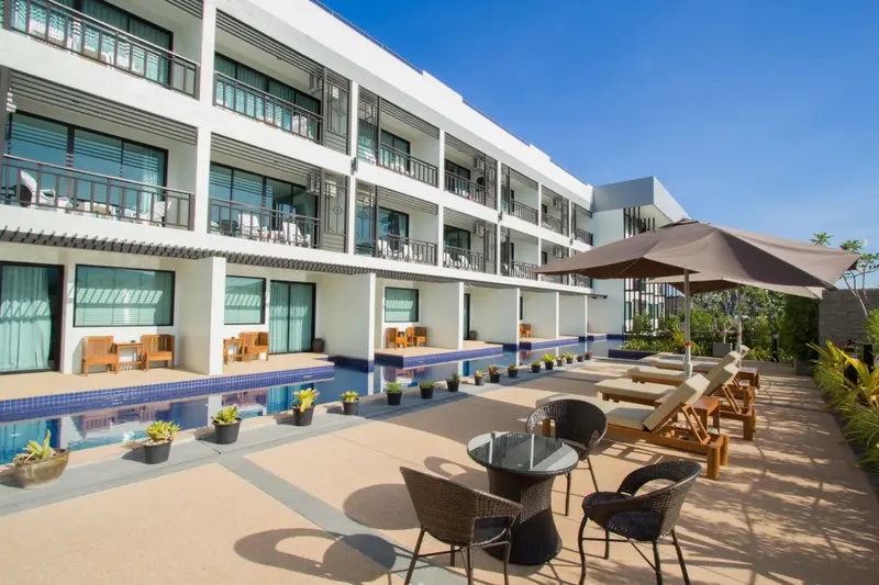 Terrasse avec mobilier de jardin devant un bâtiment blanc.