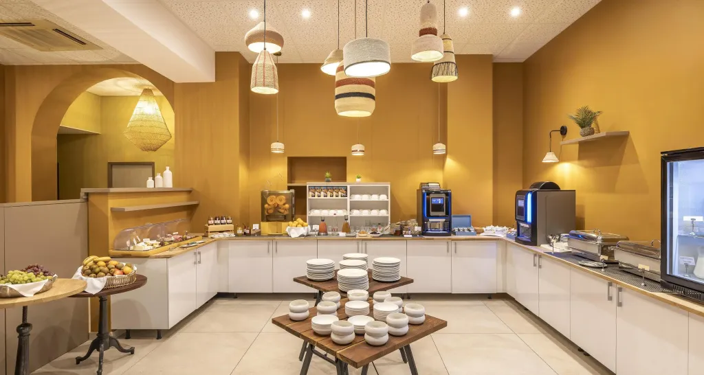 Un buffet propose une variété de plats et de boissons dans une salle lumineuse.