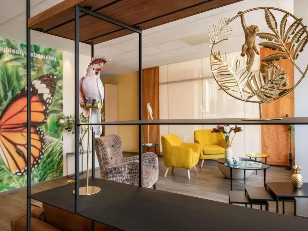 Un espace de détente lumineux avec des fauteuils colorés et une décoration tropicale.