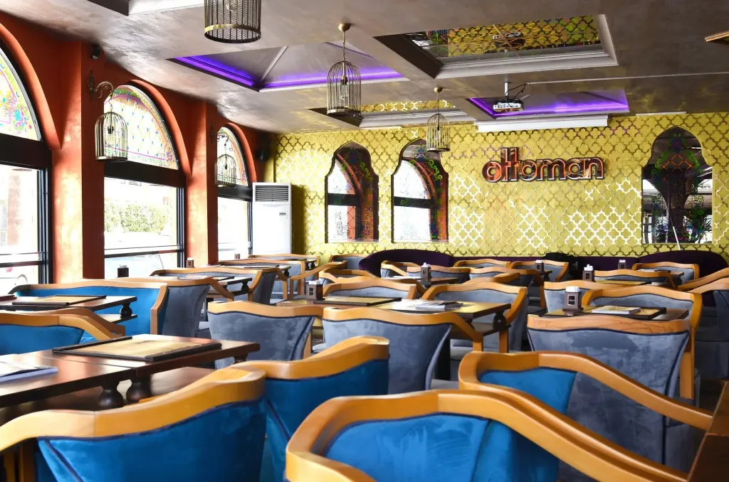 Une salle de restaurant lumineuse avec des tables dressées et des sièges confortables.