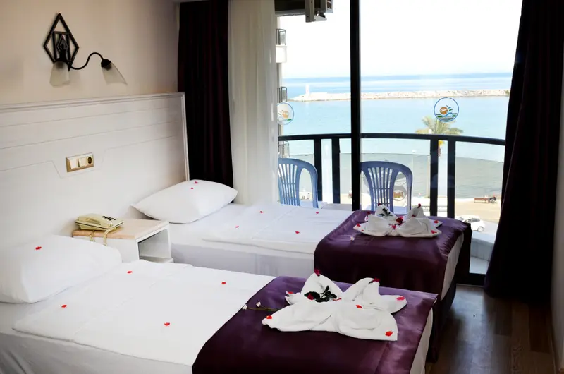 Chambre avec deux lits simples donnant sur une vue mer.