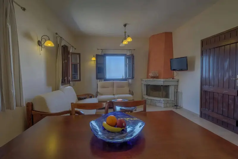 Une table en bois est mise en scène avec un saladier de fruits frais dans une pièce lumineuse.