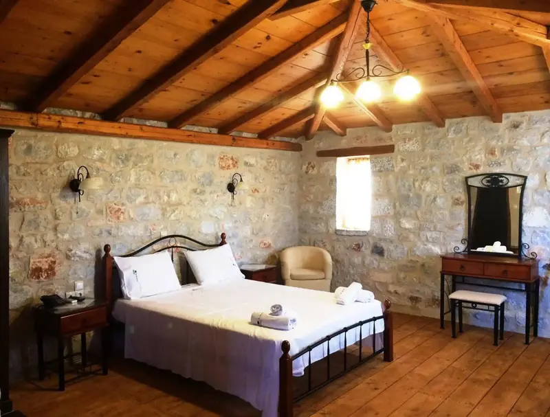 Une chambre à coucher lumineuse avec un lit à baldaquin et des murs en pierre.