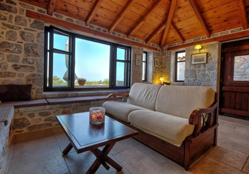 Espace de détente intérieur avec canapé et table basse devant une fenêtre.
