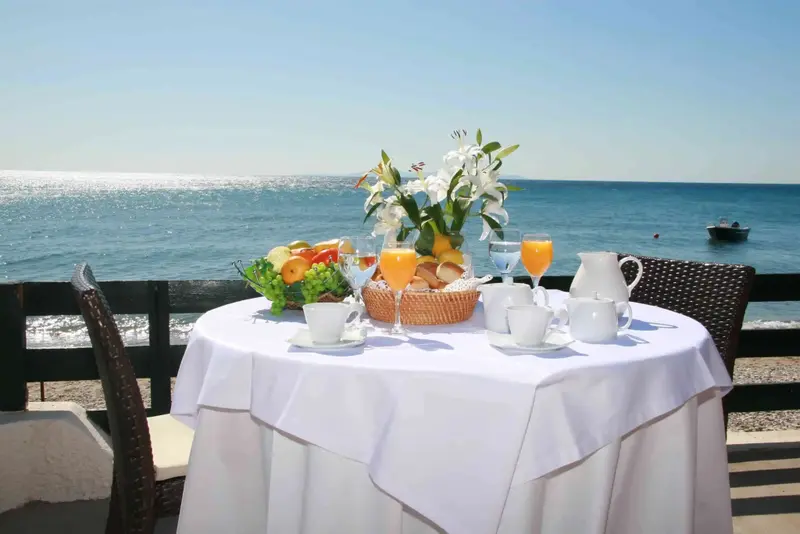 Une table dressée avec un petit-déjeuner face à la mer.