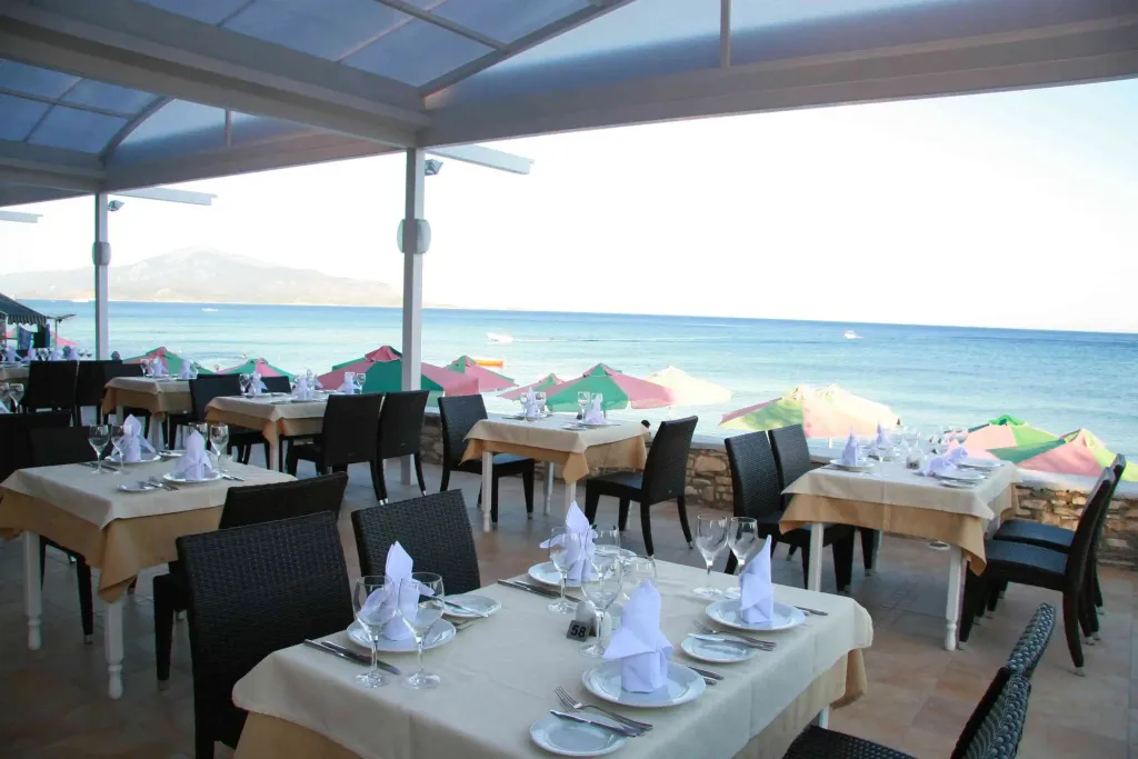 Tables dressées en terrasse avec vue sur la mer.
