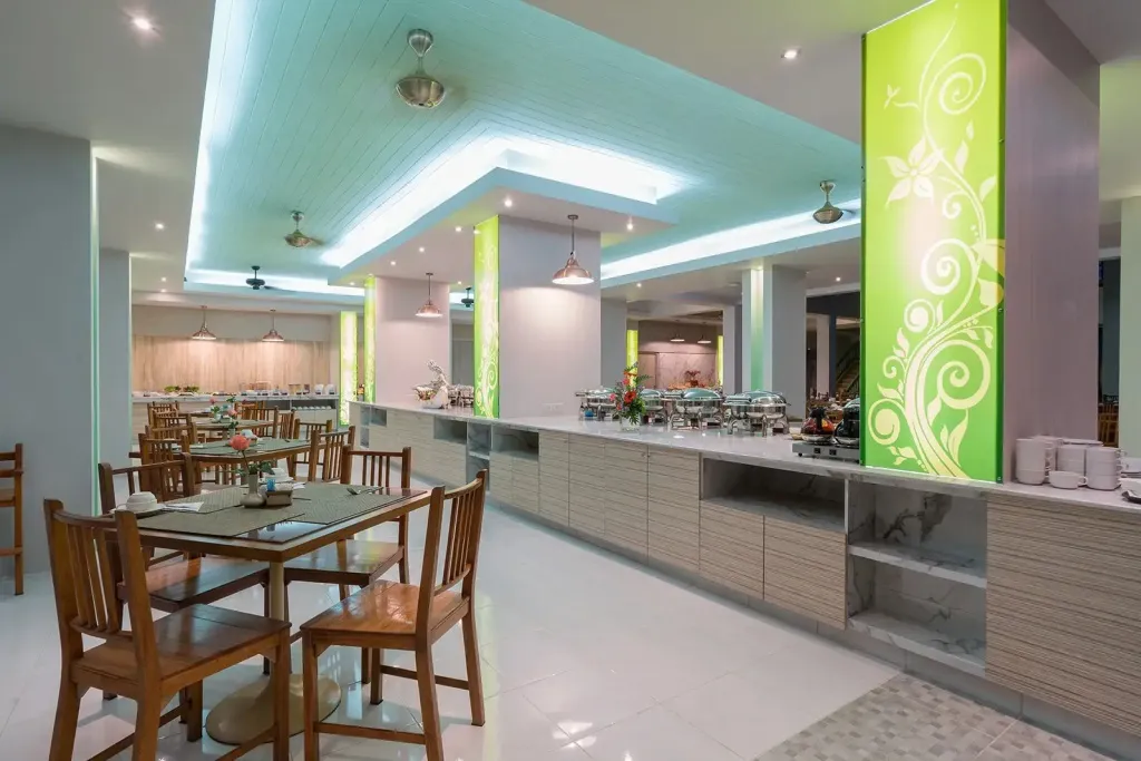 Une salle lumineuse avec des tables dressées et un buffet garni.