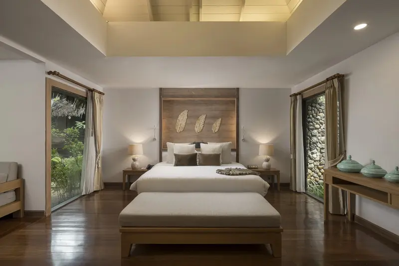 Une chambre lumineuse avec un grand lit et un accès à l'extérieur.