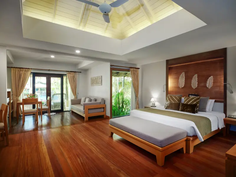 Une chambre spacieuse avec un lit king-size et un espace salon.