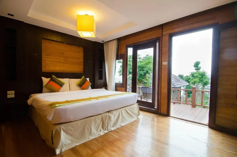 Une chambre lumineuse avec un grand lit et un accès à une terrasse.