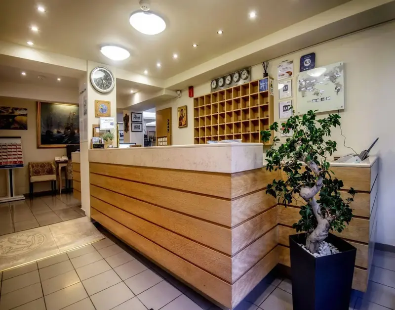 Un comptoir d'accueil lumineux avec des casiers et une plante en pot.