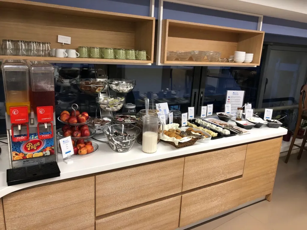 Un buffet propose des viennoiseries, des fruits et des boissons.
