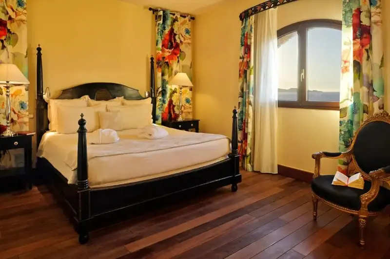 Une chambre lumineuse avec un grand lit à baldaquin et un fauteuil.
