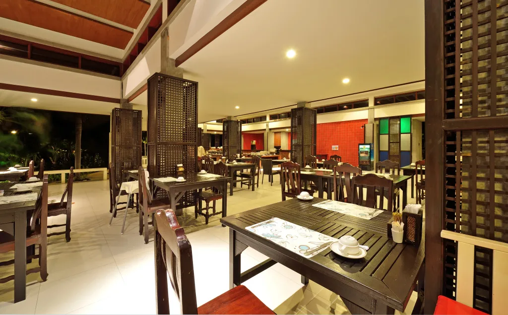 Une salle de restaurant lumineuse avec des tables dressées pour le service.