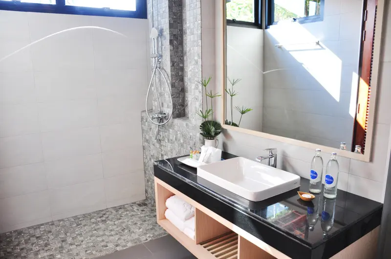 Une salle de bain moderne avec douche à l'italienne et vasque sur meuble.