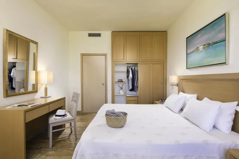 Une chambre lumineuse avec un grand lit et un espace bureau.