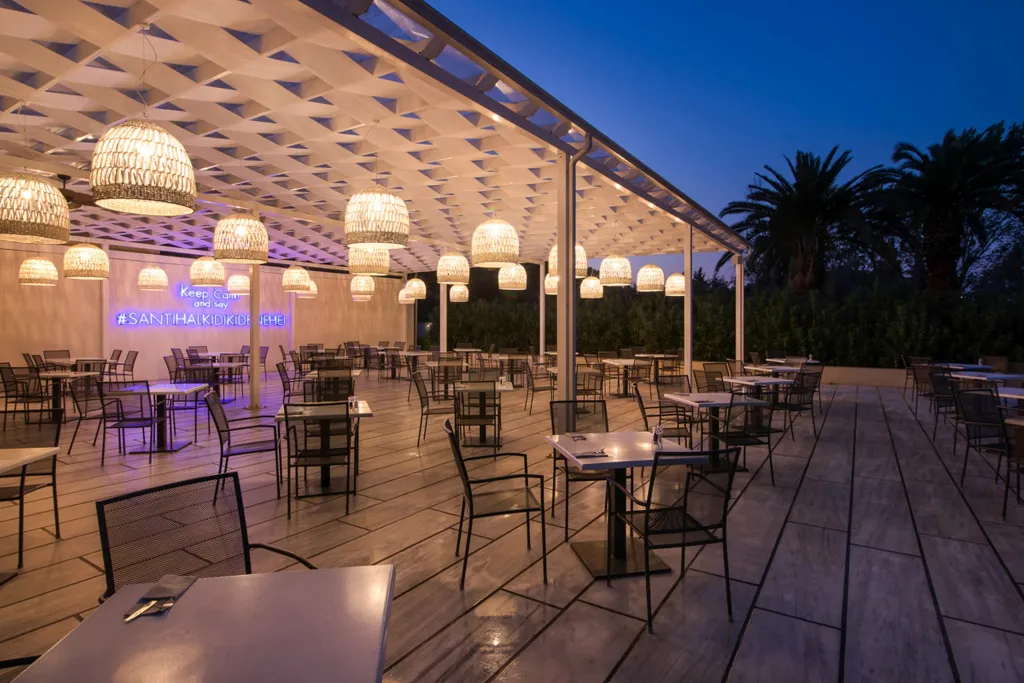 Terrasse ombragée avec tables et chaises disposées pour les repas.
