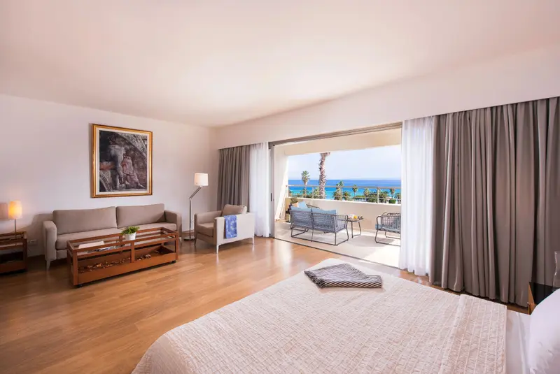 Une chambre lumineuse s'ouvre sur une terrasse avec vue sur la mer.