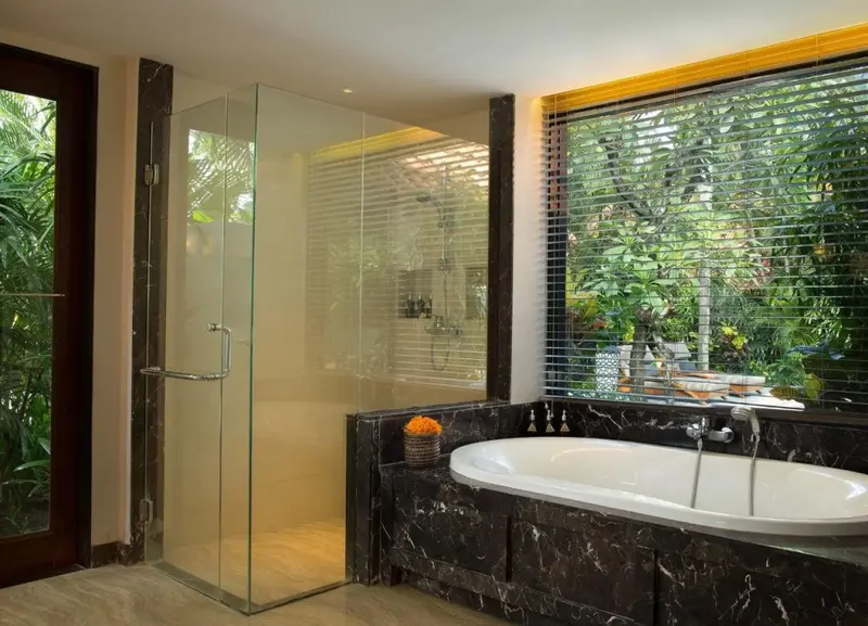 Une salle de bain lumineuse avec baignoire et douche à l'italienne.