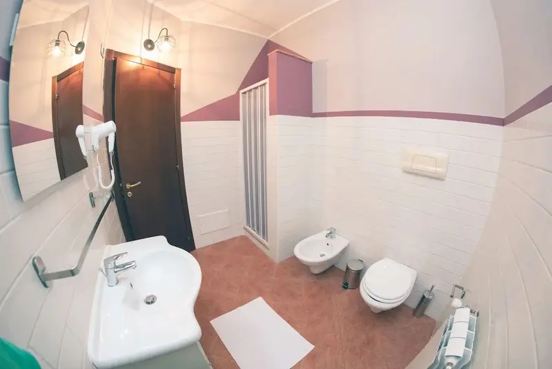 Une salle de bain claire avec lavabo, bidet et toilettes.