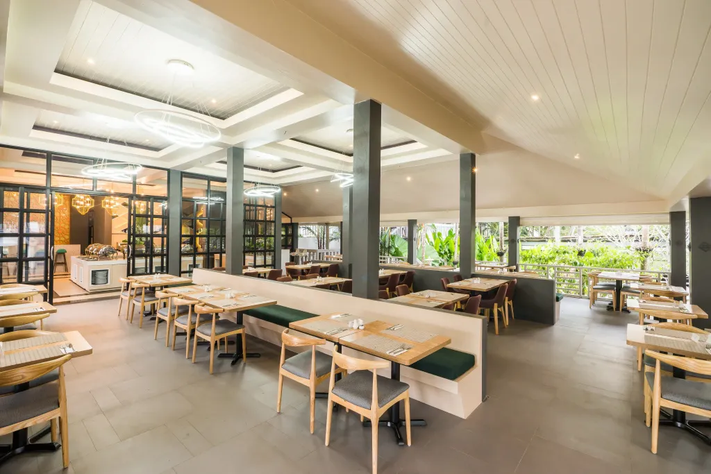 Une salle lumineuse avec des tables et des chaises pour les repas.