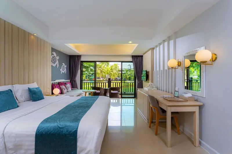 Une chambre lumineuse avec un grand lit et un bureau donnant sur une terrasse.