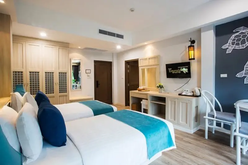 Une chambre lumineuse avec deux lits simples et un coin repas.