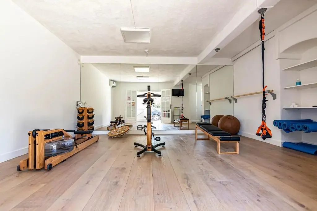 Une salle lumineuse avec des équipements de fitness et des miroirs.