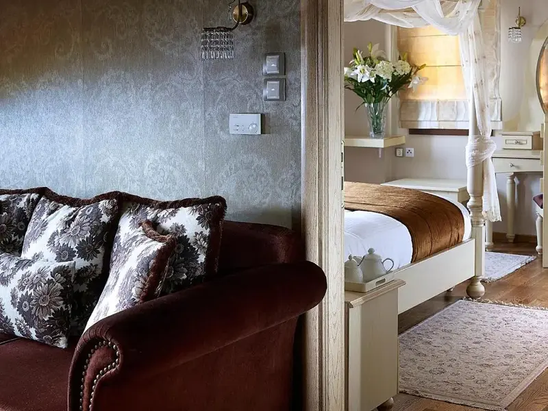 Un canape confortable est place dans un espace interieur decoratif avec un lit a baldaquin en fond.