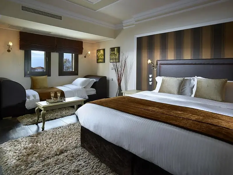Une chambre spacieuse avec un grand lit et un canapé près d'une fenêtre.