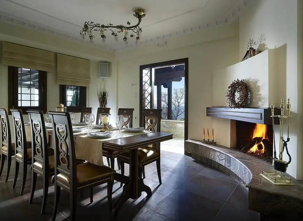 Une salle à manger lumineuse avec une table dressée et une cheminée.
