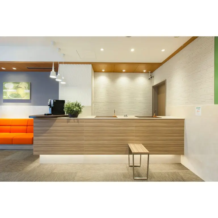 Un comptoir d'accueil moderne avec un canapé orange en face.