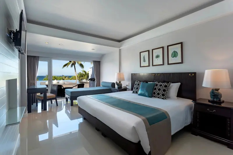 Une chambre lumineuse avec un grand lit et une vue sur la mer.