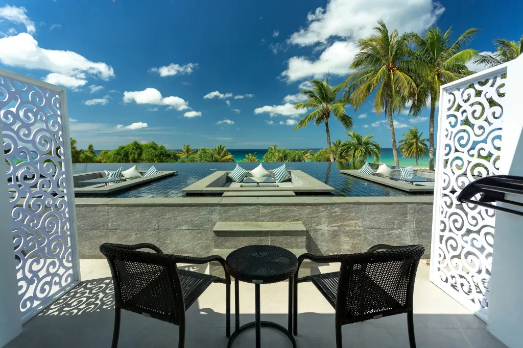 Terrasse avec mobilier d'extérieur donnant sur une piscine à débordement et la mer.