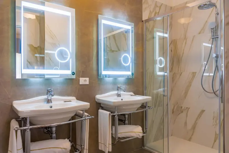 Une salle de bain moderne avec deux vasques et une douche à l'italienne.