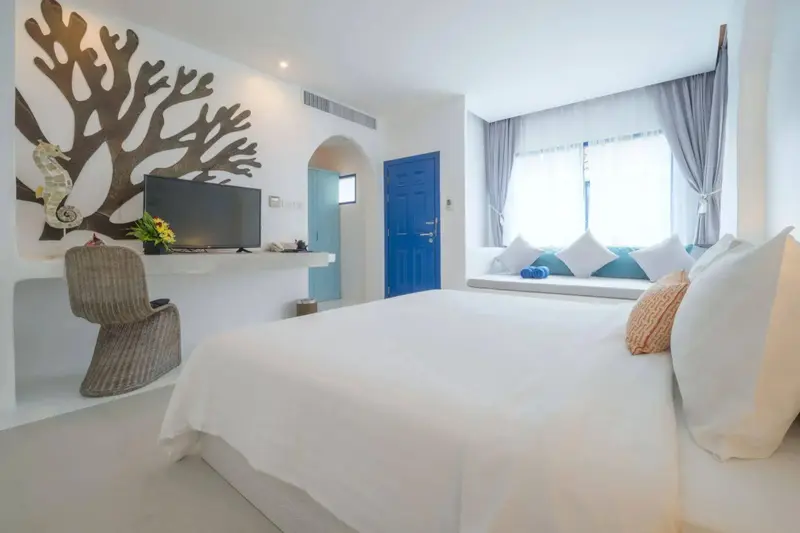 Une chambre lumineuse avec un grand lit et une décoration marine.