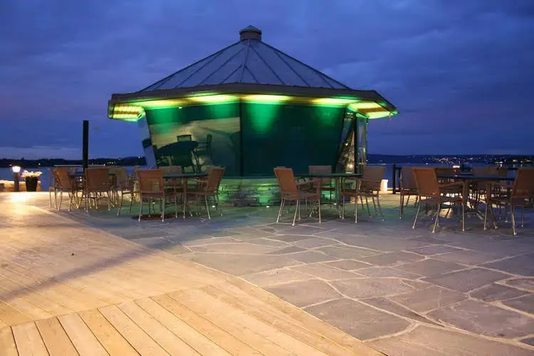 Terrasse lumineuse avec mobilier de jardin et vue sur la mer.