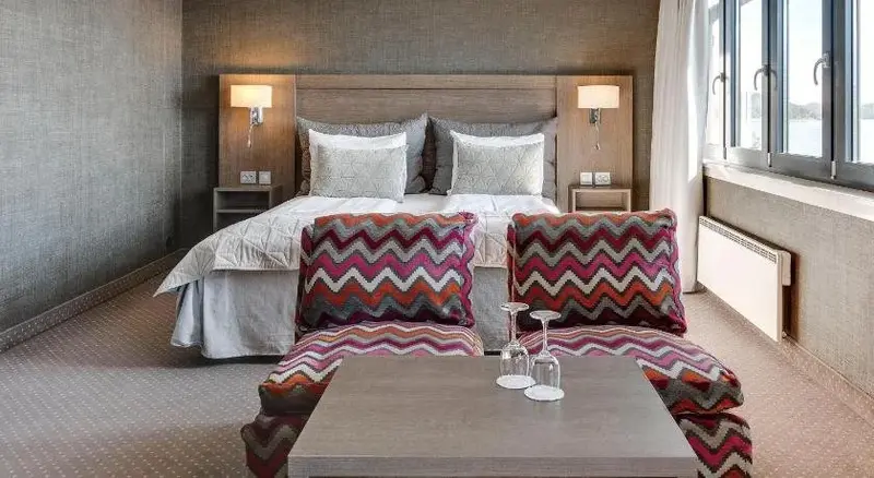 Une chambre moderne avec un grand lit et un coin salon.