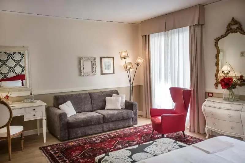 Une pièce lumineuse est aménagée avec un canapé, un fauteuil et un bureau.
