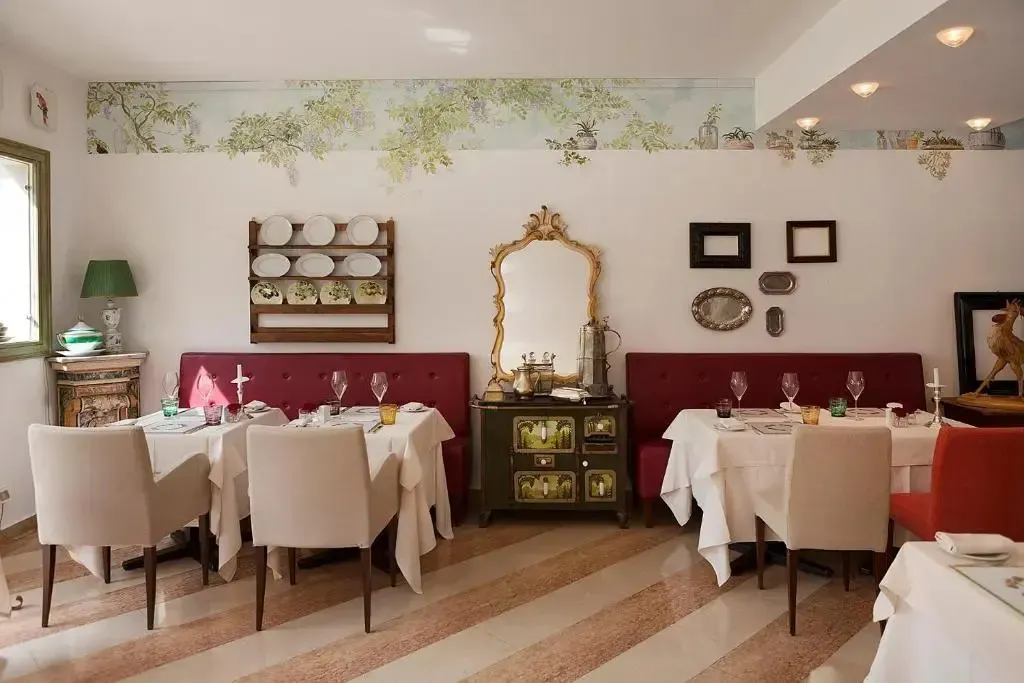 Une salle de restaurant lumineuse avec des tables nappées et des chaises claires.
