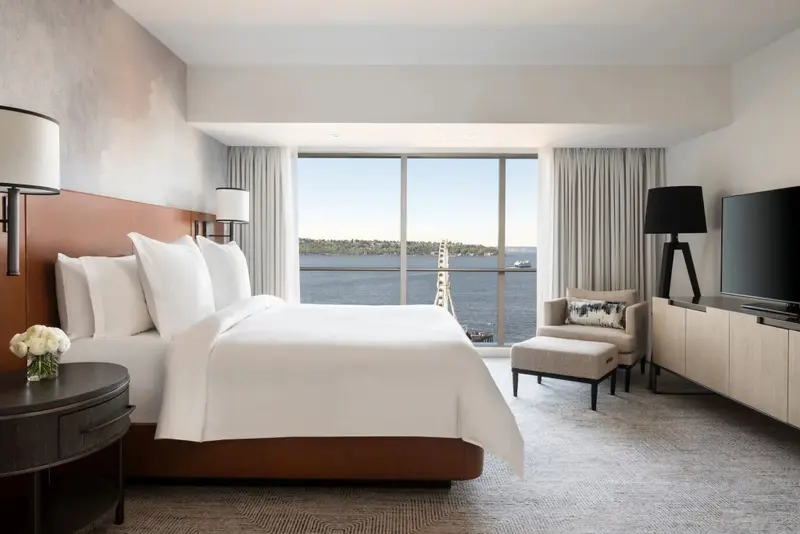 Une chambre lumineuse avec un grand lit et une vue sur la mer.