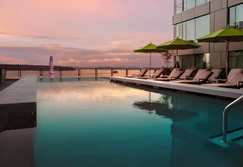 Une piscine à débordement offre une vue sur la mer au coucher du soleil.