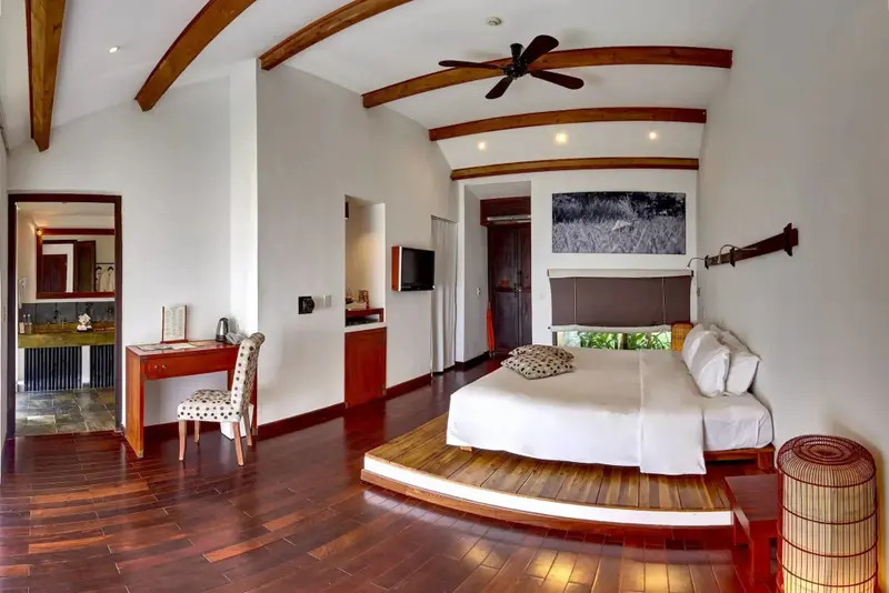 Une chambre spacieuse avec un lit king-size et un bureau en bois.