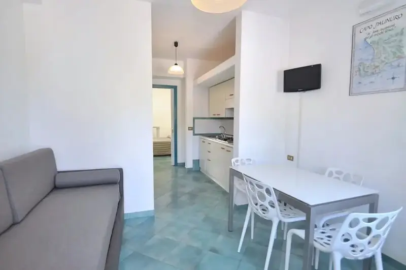 Espace de vie lumineux avec canapé, table à manger et cuisine ouverte.