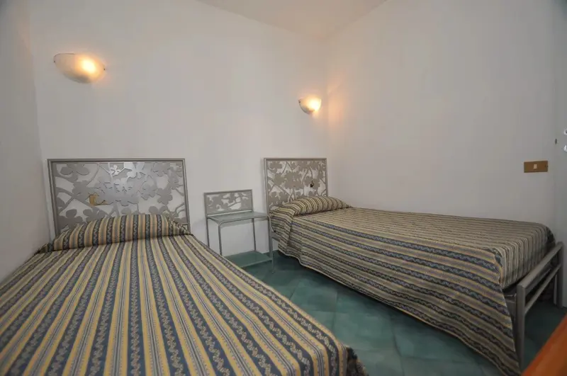 Une chambre lumineuse avec deux lits simples et des têtes de lit décoratives.