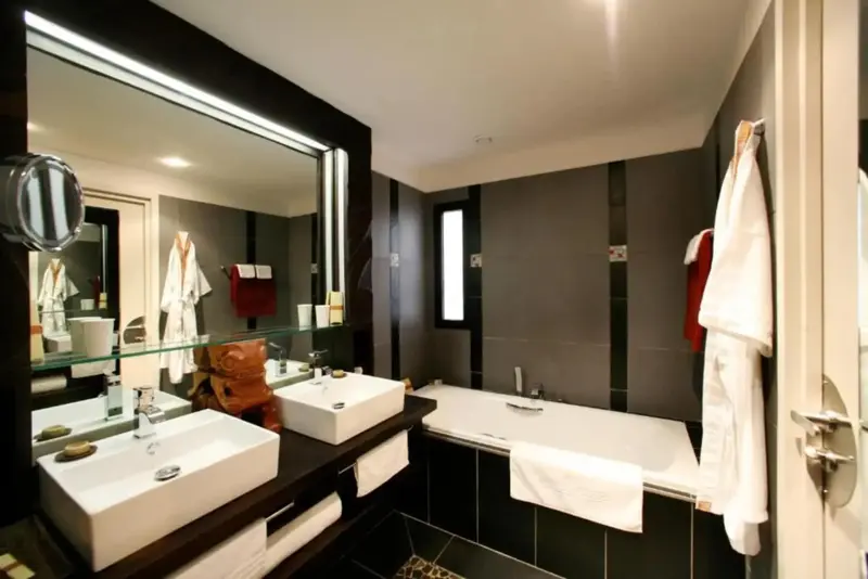 Une salle de bain moderne avec deux vasques et une baignoire.
