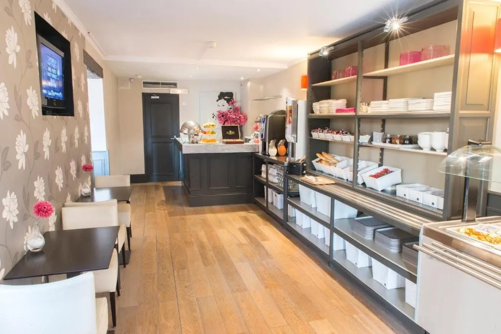 Une salle lumineuse présente un buffet garni et des tables pour les repas.